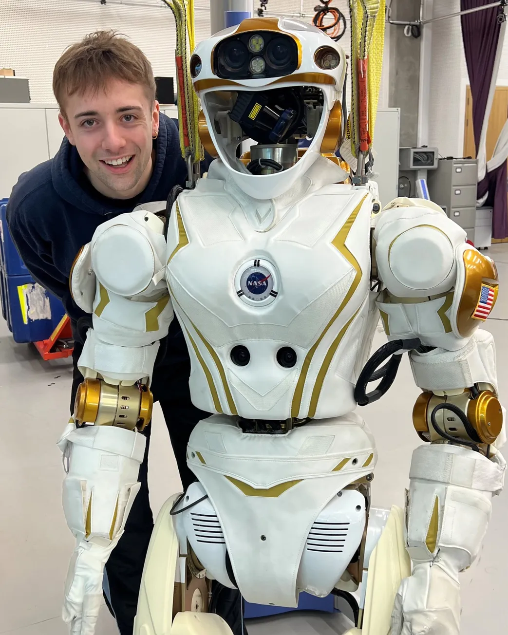 Willem Davison standing beside a humanoid robot